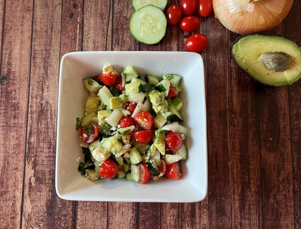 A bowl with cucumber tomato and avocado salad