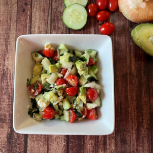 A bowl with cucumber tomato and avocado salad