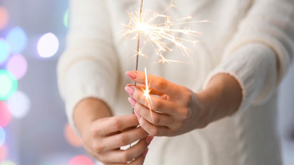 Stop Making Resolutions and Get Well Naturally in 2022- woman holding a sparkler
