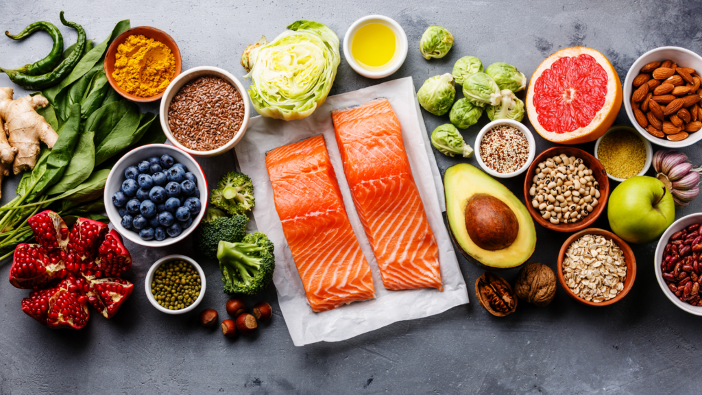 Want to improve heart health? Eat more of these foods. A table with foods like salmon, berries, avocado, nuts, broccoli
